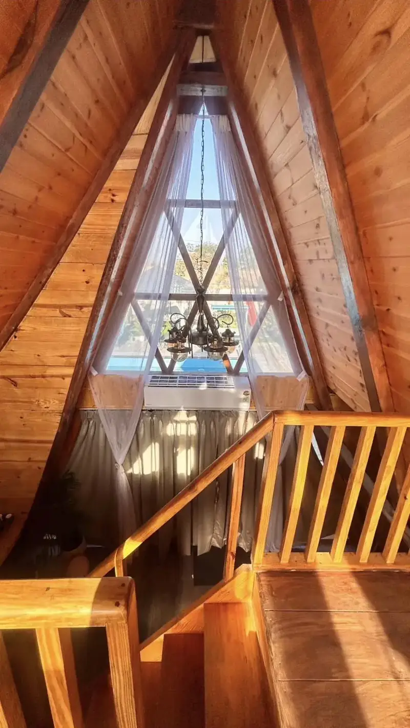 Chandelier and triangle window looking out over the pool